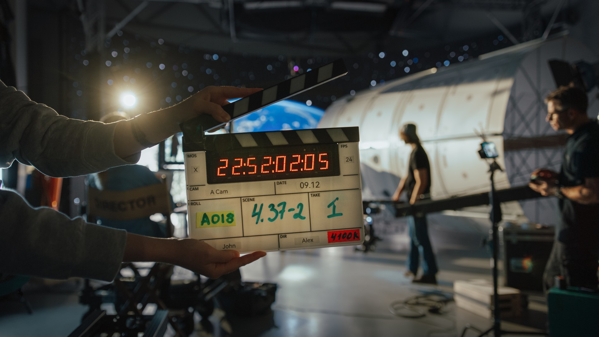 Director Filming Ad Shoot With Astronaut Fixing Satellite. Actor Floats on Rope Against Digital Earth Backdrop. Behind-the-scenes of Commercial Production.